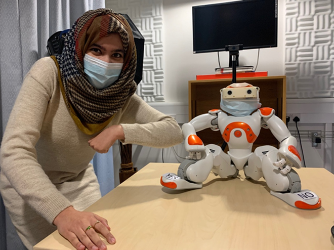 Nida, a PhD student at the AFAR Lab with the Nao Robot.