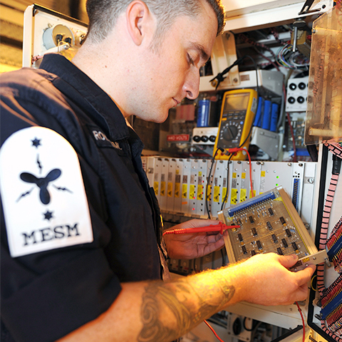A Royal Navy engineer working on a submarine